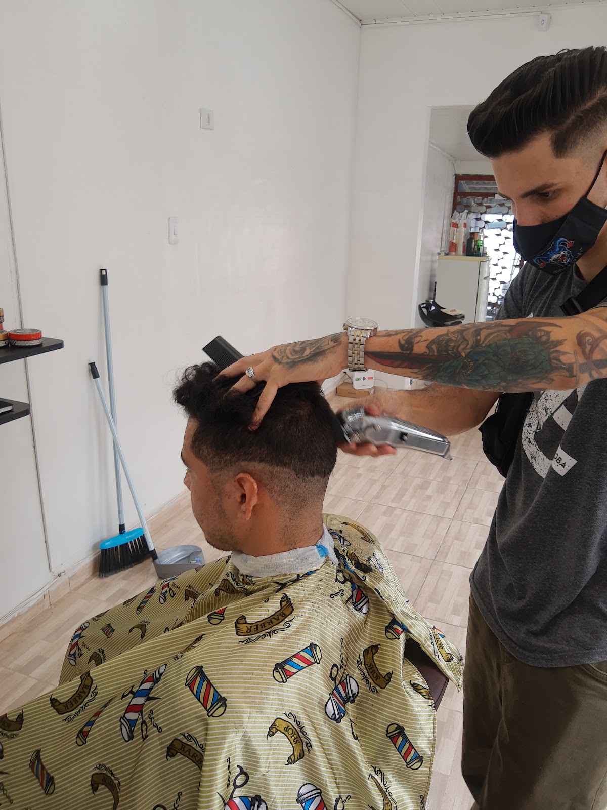 Barbeiro cortando o cabelo de um cliente na Barbearia Montalvão